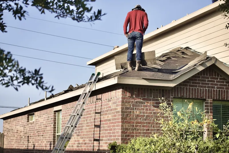 Professional roofer working on a residential roof in Waltz